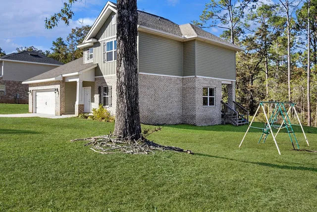 a backyard of a house with plants and a yard