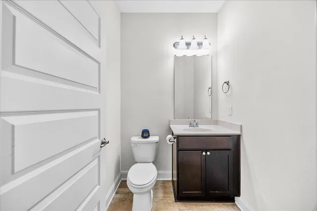 a bathroom with a granite countertop sink toilet and mirror