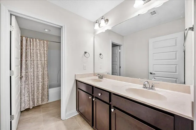 a bathroom with a double vanity sink a mirror and a shower