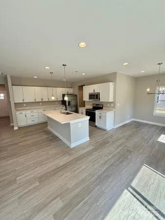 a large kitchen with a center island and stainless steel appliances