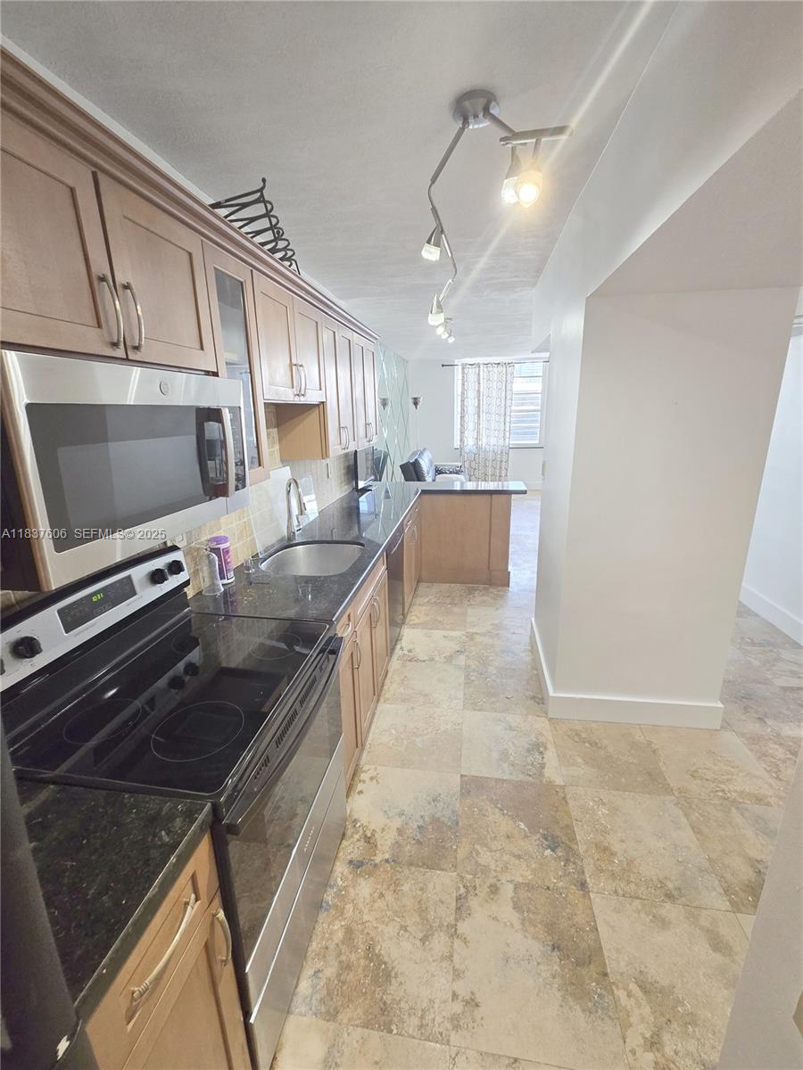 100 Lincoln Road, Unit 1206 Miami Beach, FL 33139 - Photo 11 of 18 a large kitchen with granite countertop a stove and a sink