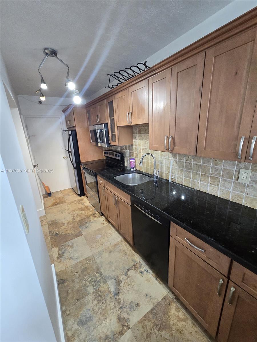 100 Lincoln Road, Unit 1206 Miami Beach, FL 33139 - Photo 10 of 18 a kitchen with granite countertop sink stainless steel appliances and cabinets