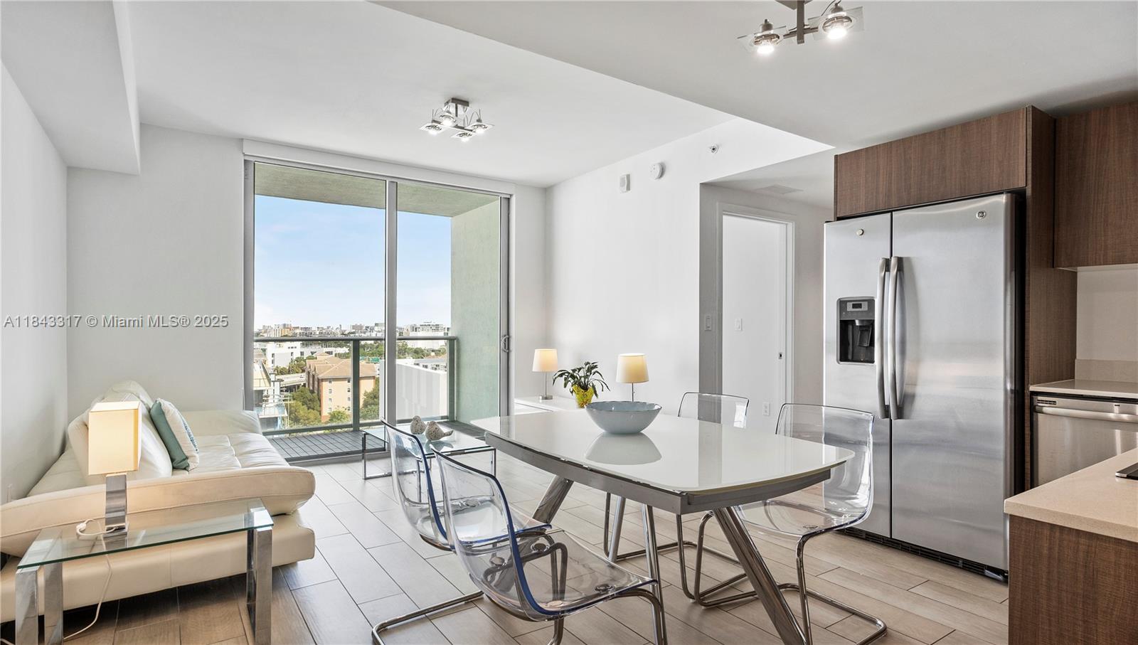 1600 Southwest 1st Avenue, Unit 1104 Miami, FL 33129 - Photo 2 of 22 a kitchen with a table chairs refrigerator and cabinets