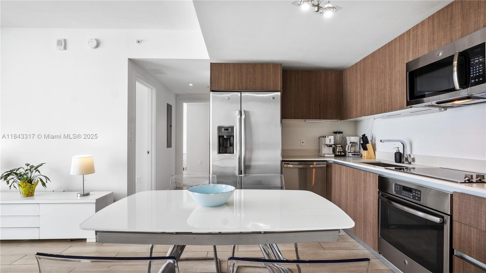 1600 Southwest 1st Avenue, Unit 1104 Miami, FL 33129 - Photo 3 of 22 a kitchen with stainless steel appliances a sink a stove a microwave a refrigerator and cabinets