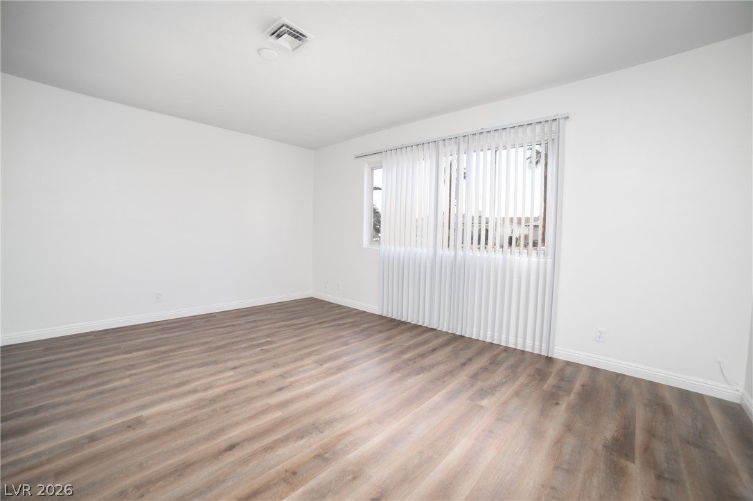 3556 Ruth Drive Las Vegas, NV 89121 - Photo 9 of 21 Laminate flooring and a wide window with vertical blinds create an adaptable living area.