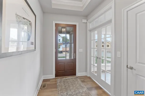a view of a hallway with wooden floor and entryway
