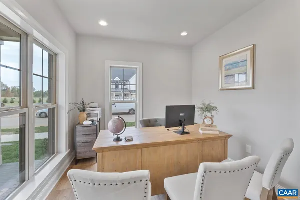 a large kitchen with kitchen island a wooden floor and a view of living room
