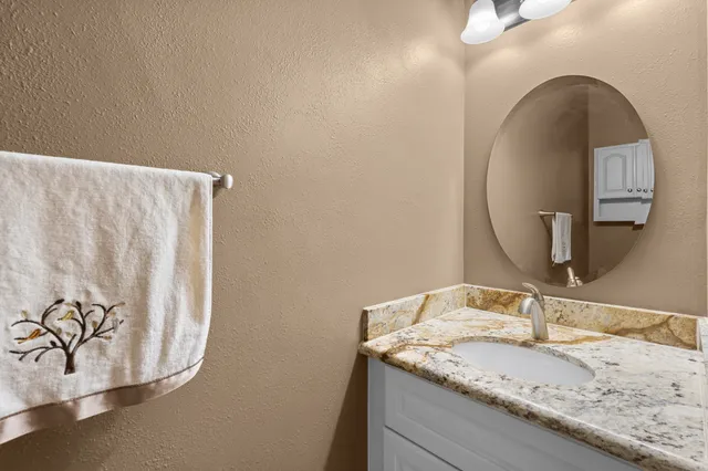 a bathroom with a granite countertop sink and a mirror