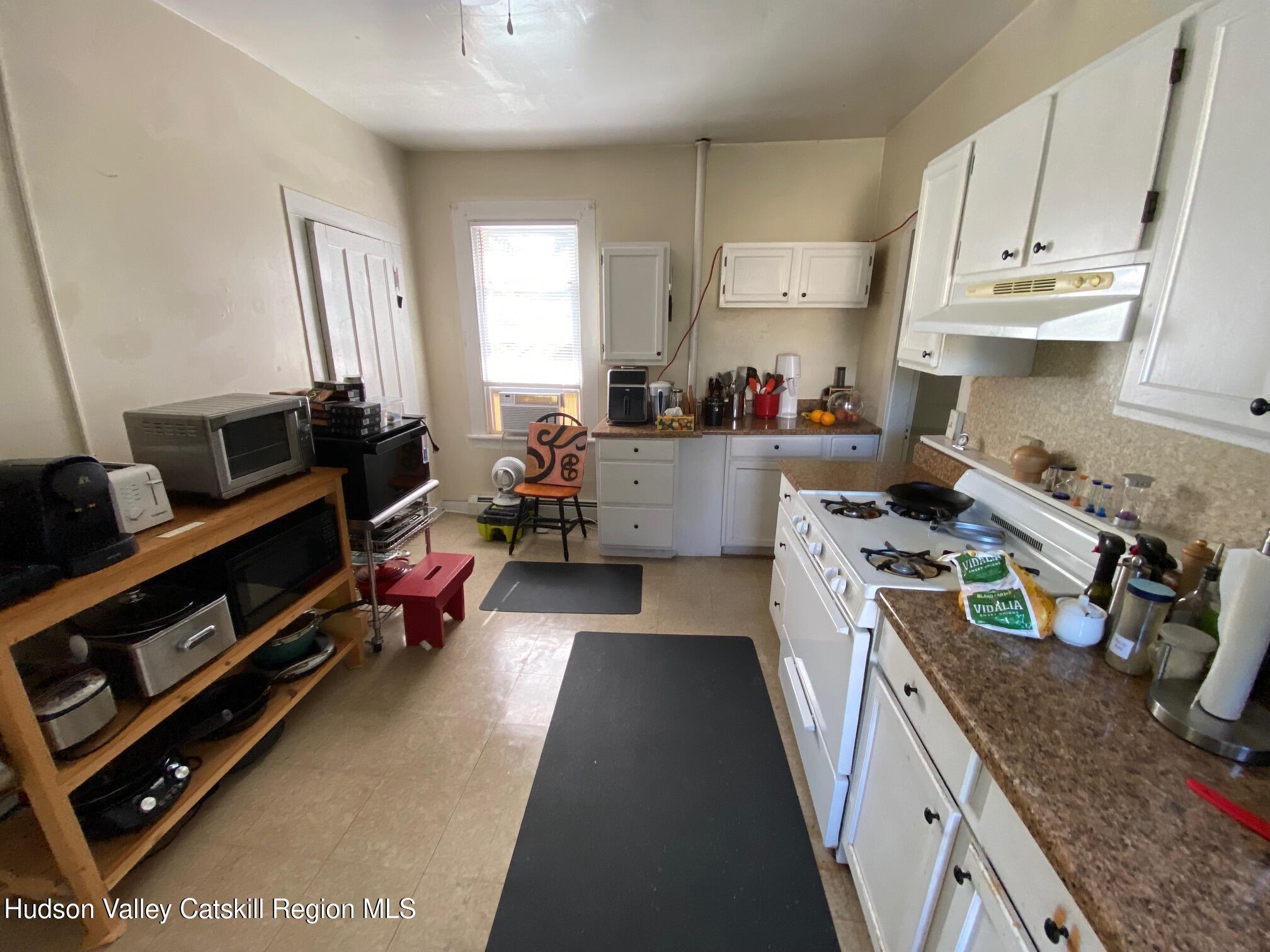 316 State Street Hudson, NY 12534 - Photo 18 of 29 a kitchen with a stove a sink and a refrigerator