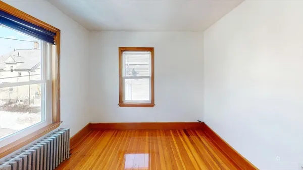 a view of a room with wooden floor and windows