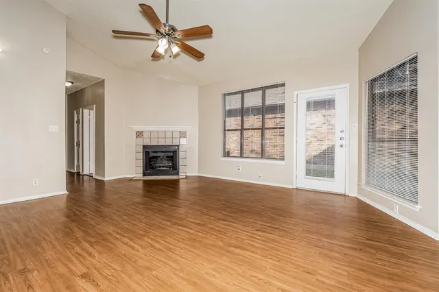 wooden floor fireplace and windows in an empty room