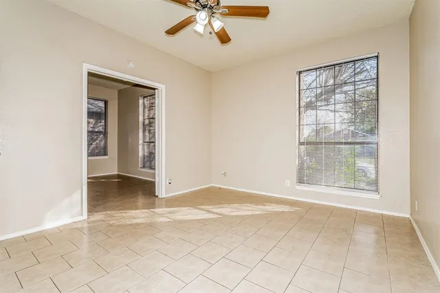 an empty room with fan and windows