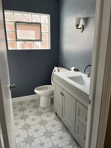 a bathroom with a sink toilet and window