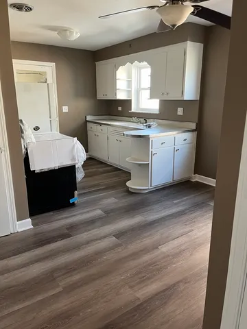 a large kitchen with stainless steel appliances granite countertop a sink stove and wooden floor