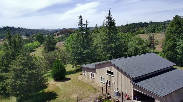 an aerial view of a house with a yard and mountain view