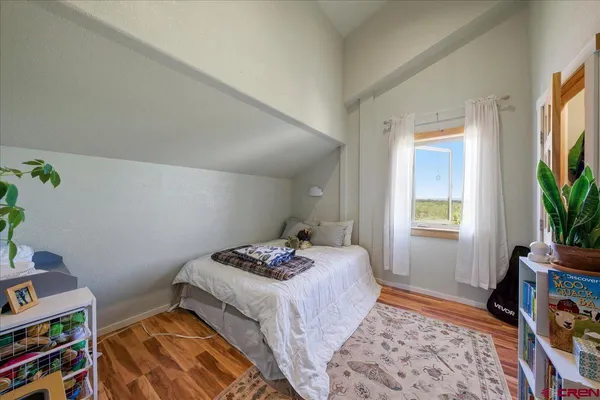 a bedroom with a bed and a flat tv screen on the dresser