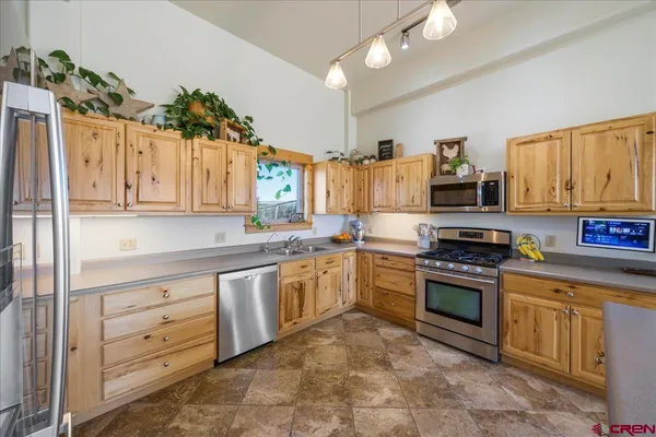 a kitchen with granite countertop a sink stainless steel appliances and cabinets