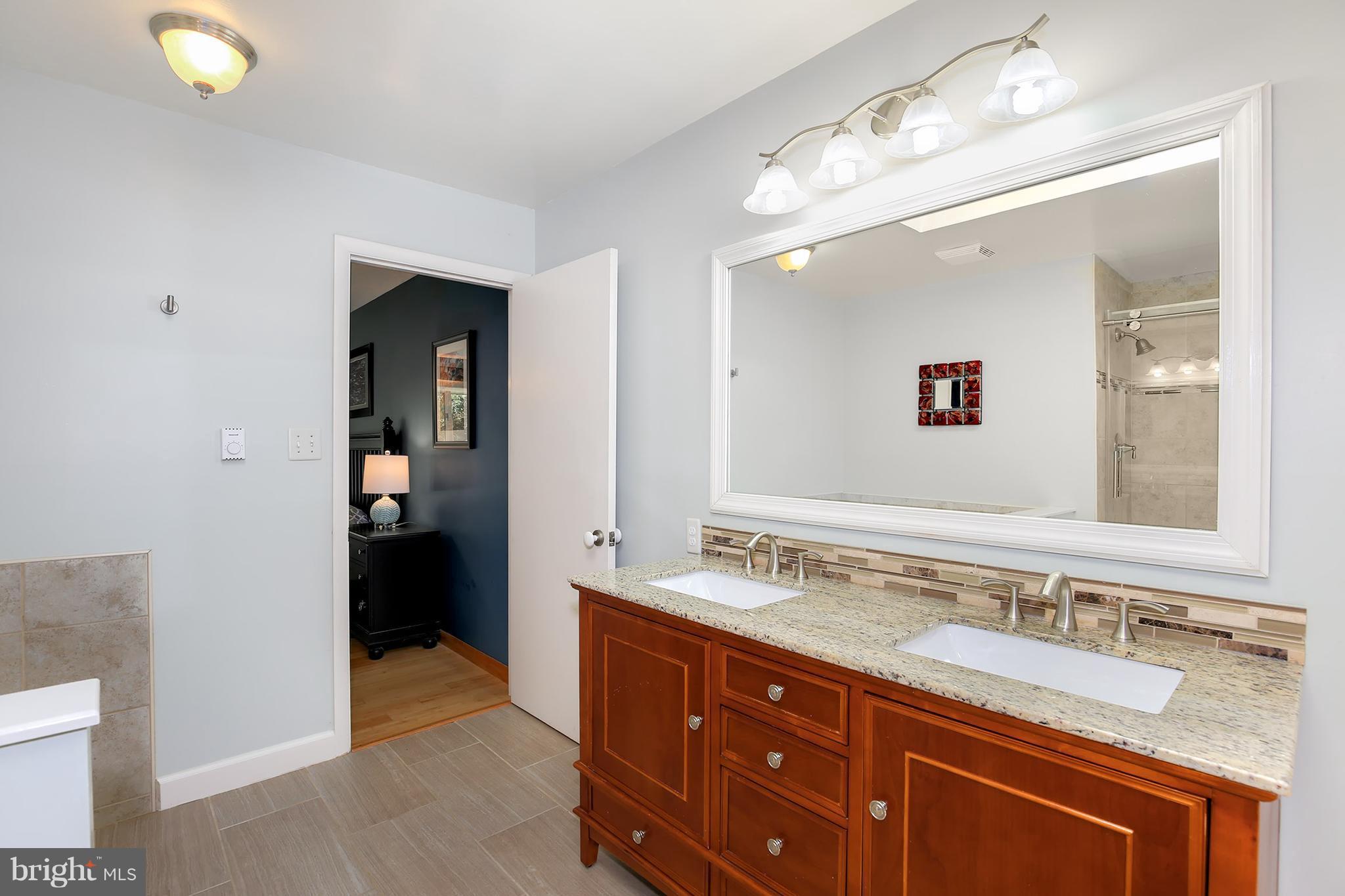 9116 Gue Road Damascus, MD 20872 - Photo 8 of 30 a spacious bathroom with a granite countertop sink and a mirror
