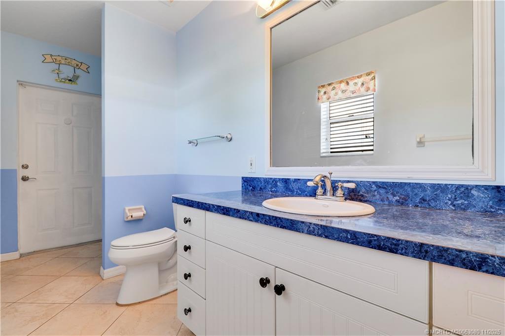 5439 Southeast Horseshoe Point Road Stuart, FL 34997 - Photo 30 of 52 a bathroom with a granite countertop sink a toilet and a mirror