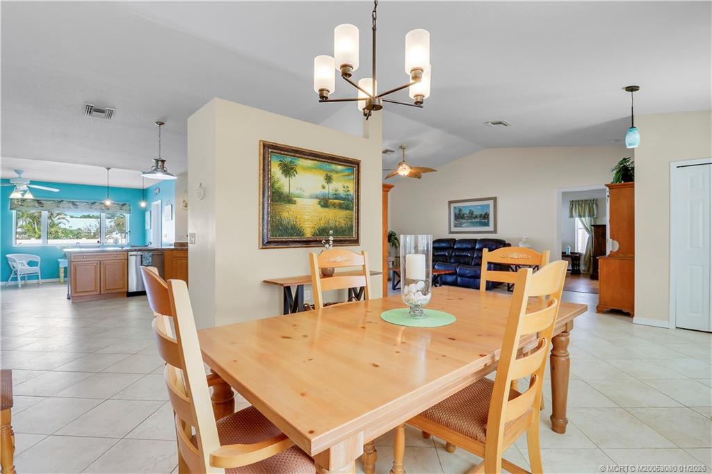 5439 Southeast Horseshoe Point Road Stuart, FL 34997 - Photo 34 of 53 a dining room with furniture a chandelier and wooden floor