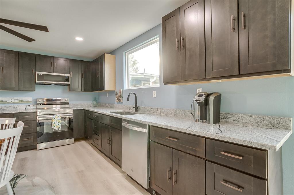 520 Deer Trail Gordon, TX 76453 - Photo 25 of 40 a kitchen with kitchen island granite countertop a sink stainless steel appliances and cabinets