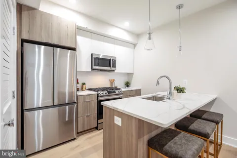 a kitchen with stainless steel appliances a refrigerator sink and microwave