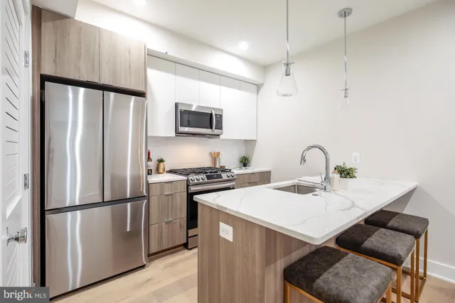 a kitchen with stainless steel appliances a refrigerator sink and microwave