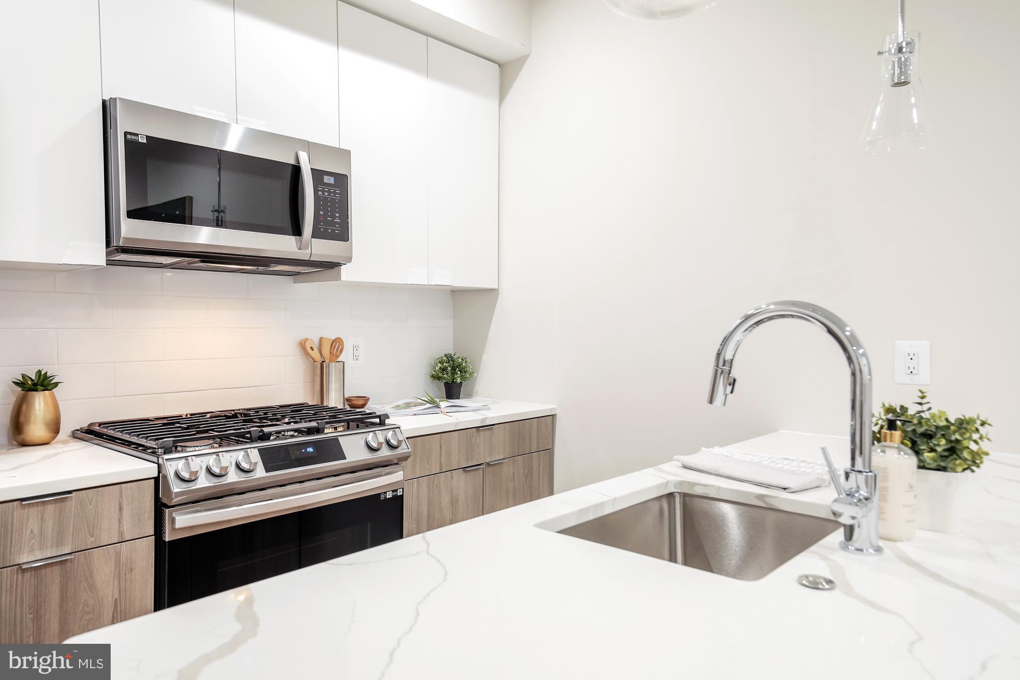 1421 Spring Road Northwest, Unit IZ 101 Washington, DC 20010 - Photo 4 of 10 a kitchen with a sink and a stove top oven