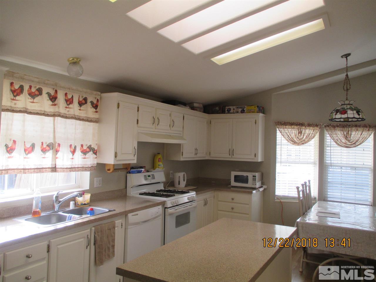 1306 Lynx Street Reno, NV 89506 - Photo 9 of 22 a kitchen with granite countertop a sink appliances cabinets and a window
