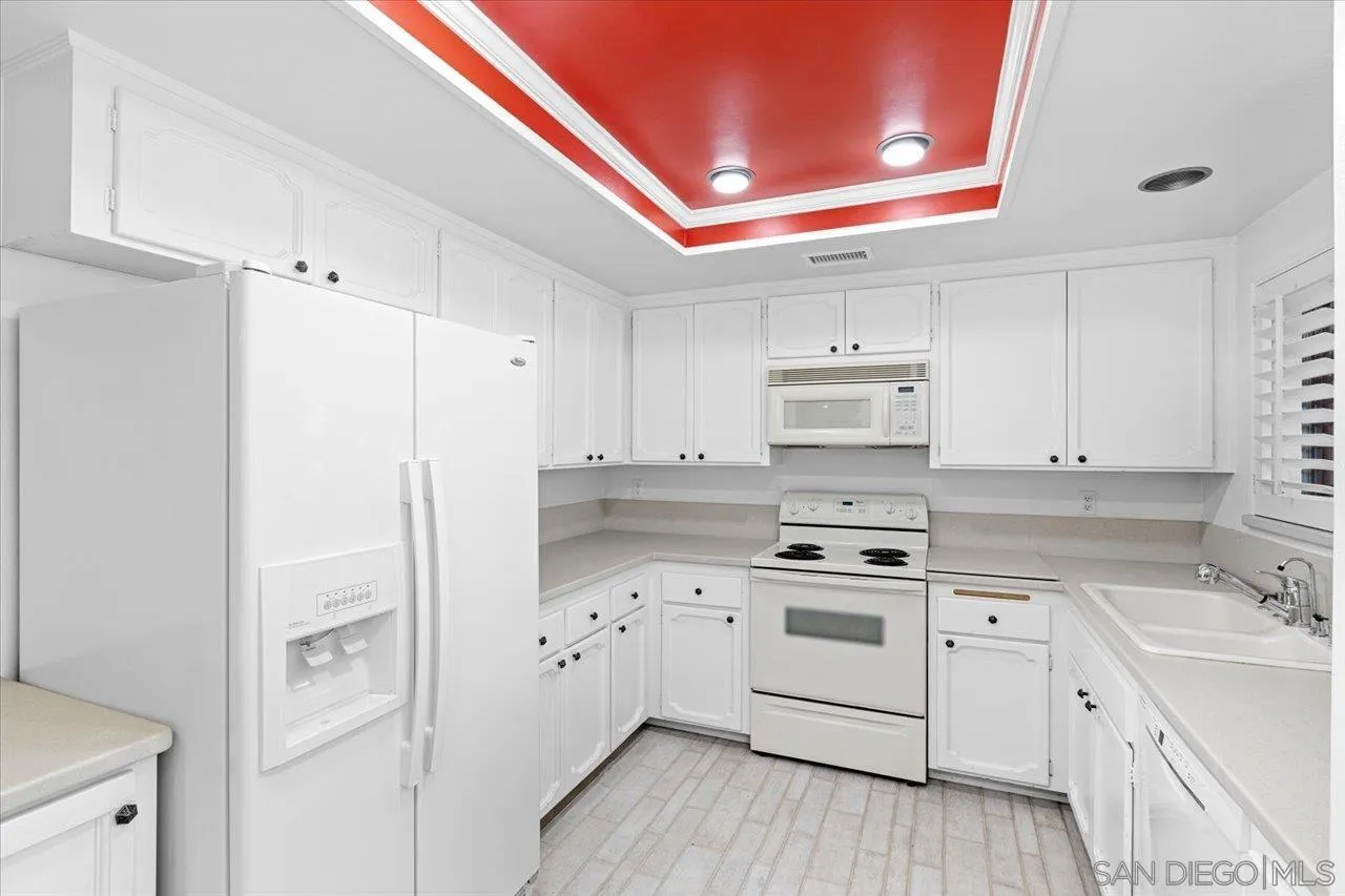 12491 Rios Road Rancho Bernardo, CA 92128 - Photo 12 of 21 a kitchen with white cabinets and white appliances