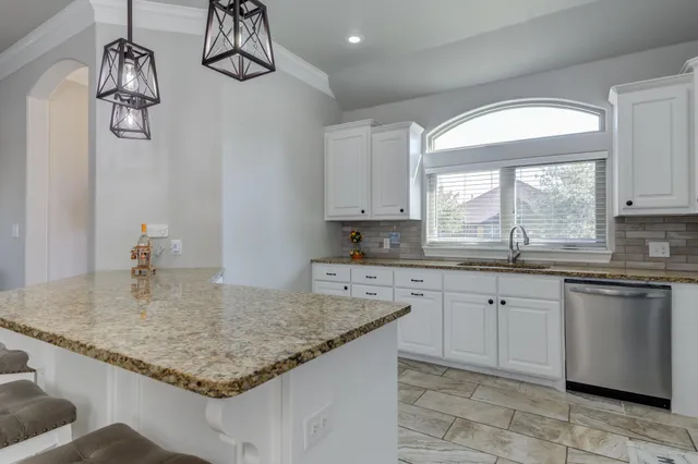 a kitchen with a sink granite counter tops and a window