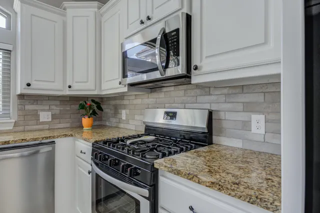 a kitchen with white cabinets and appliances