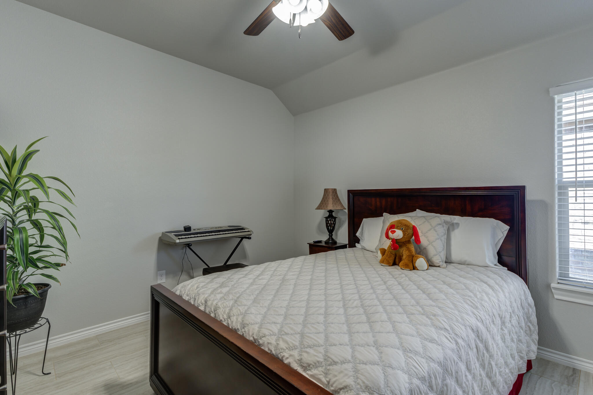 6306 87th Street Lubbock, TX 79424 - Photo 33 of 47 a bedroom with a bed and a potted plant