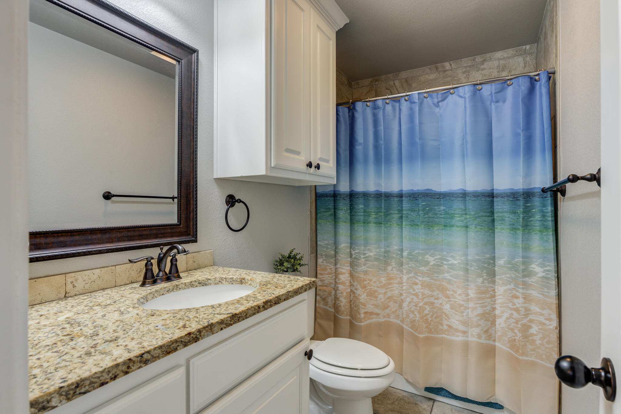 6306 87th Street Lubbock, TX 79424 - Photo 35 of 47 a bathroom with a granite countertop sink a toilet and shower