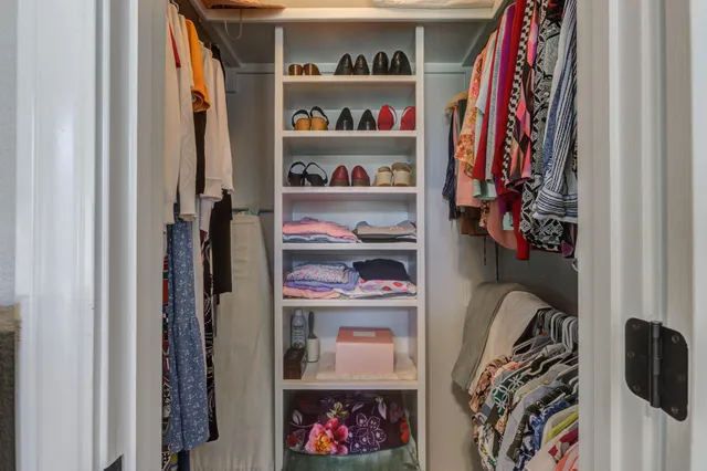 a view of walk in closet with clothes and shoes