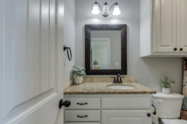 a bathroom with a granite countertop sink and a mirror