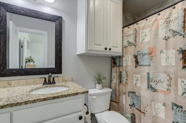 a bathroom with a granite countertop sink and a mirror