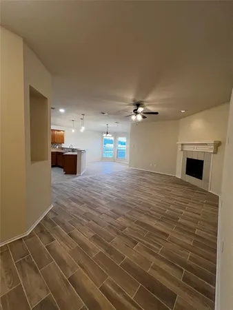 a view of a livingroom with a ceiling fan wooden floor and a ceiling fan