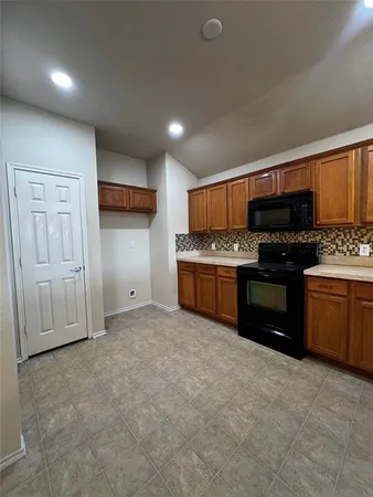 a kitchen with stainless steel appliances granite countertop a stove a sink and a refrigerator
