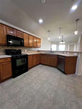 a large kitchen with granite countertop a stove and a sink
