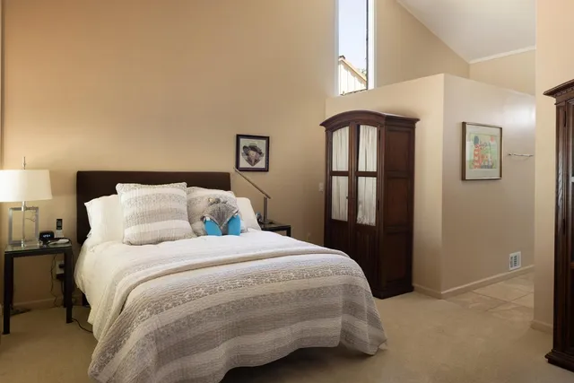 a bedroom with a bed next to a window