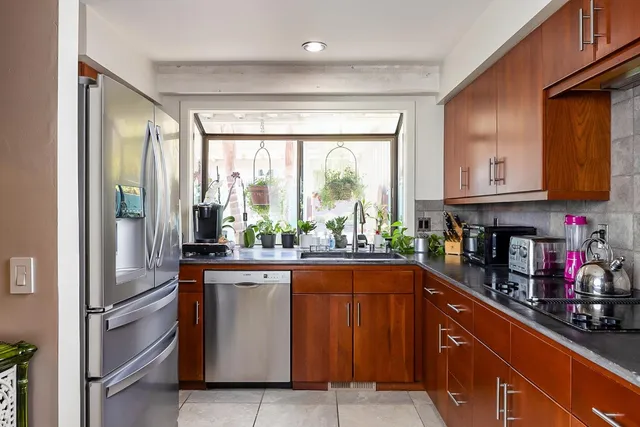 a kitchen with stainless steel appliances granite countertop a refrigerator and a sink