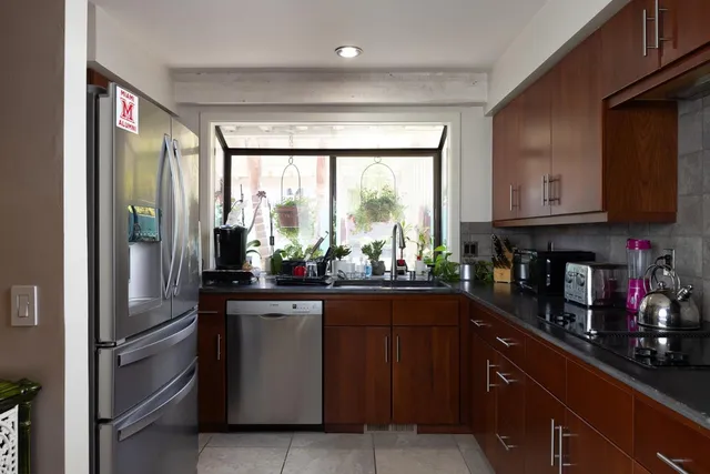 a kitchen with stainless steel appliances granite countertop a refrigerator and a sink