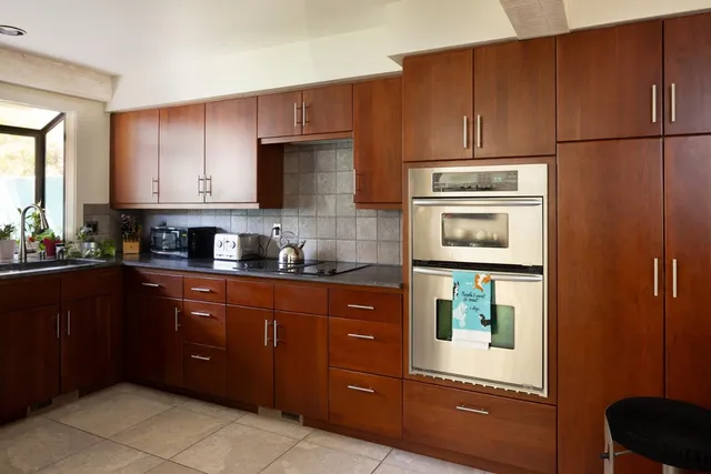 a kitchen with stainless steel appliances granite countertop a refrigerator and a stove top oven
