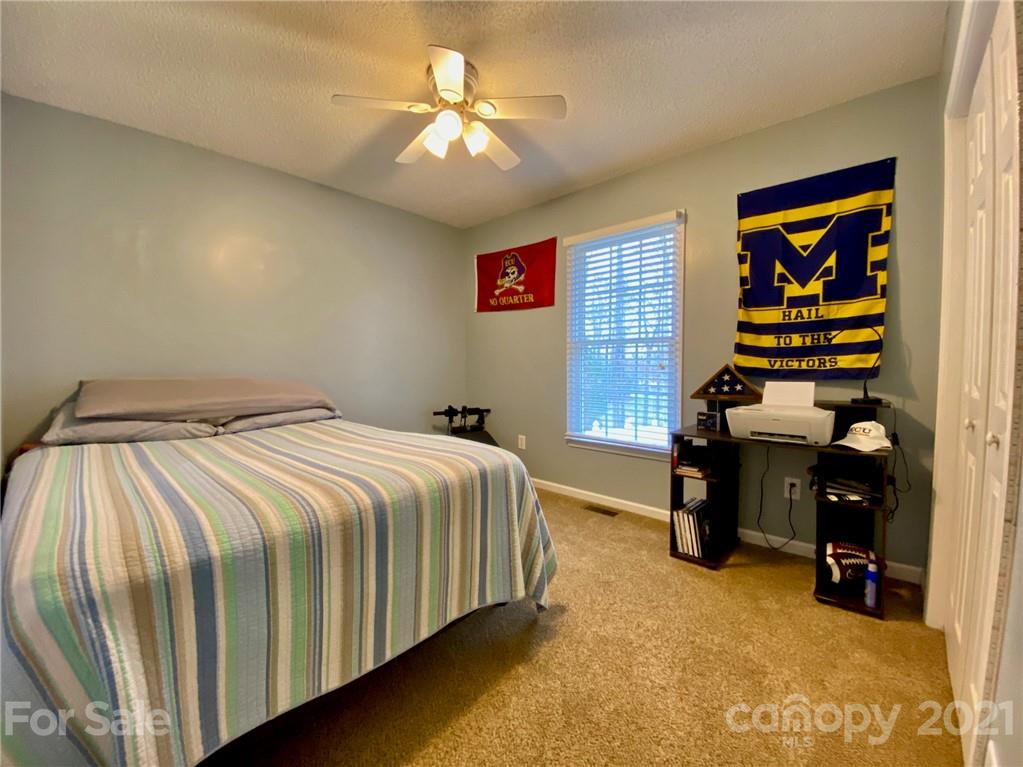 1168 Balfour Quarry Road Salisbury, NC 28146 - Photo 28 of 47 a bedroom with a bed and a chandelier