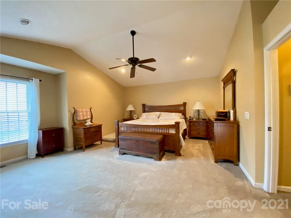 1168 Balfour Quarry Road Salisbury, NC 28146 - Photo 32 of 47 a spacious bedroom with a bed and a chandelier