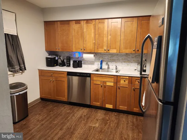 a kitchen with stainless steel appliances a sink cabinets and wooden floor