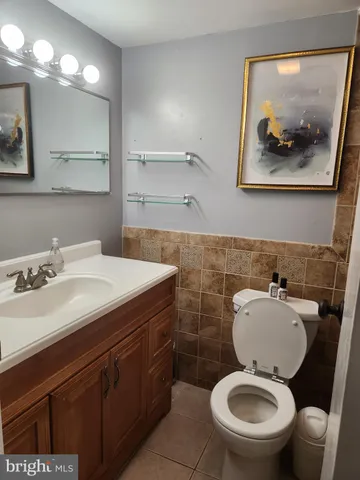 a bathroom with a toilet and a painting on the wall