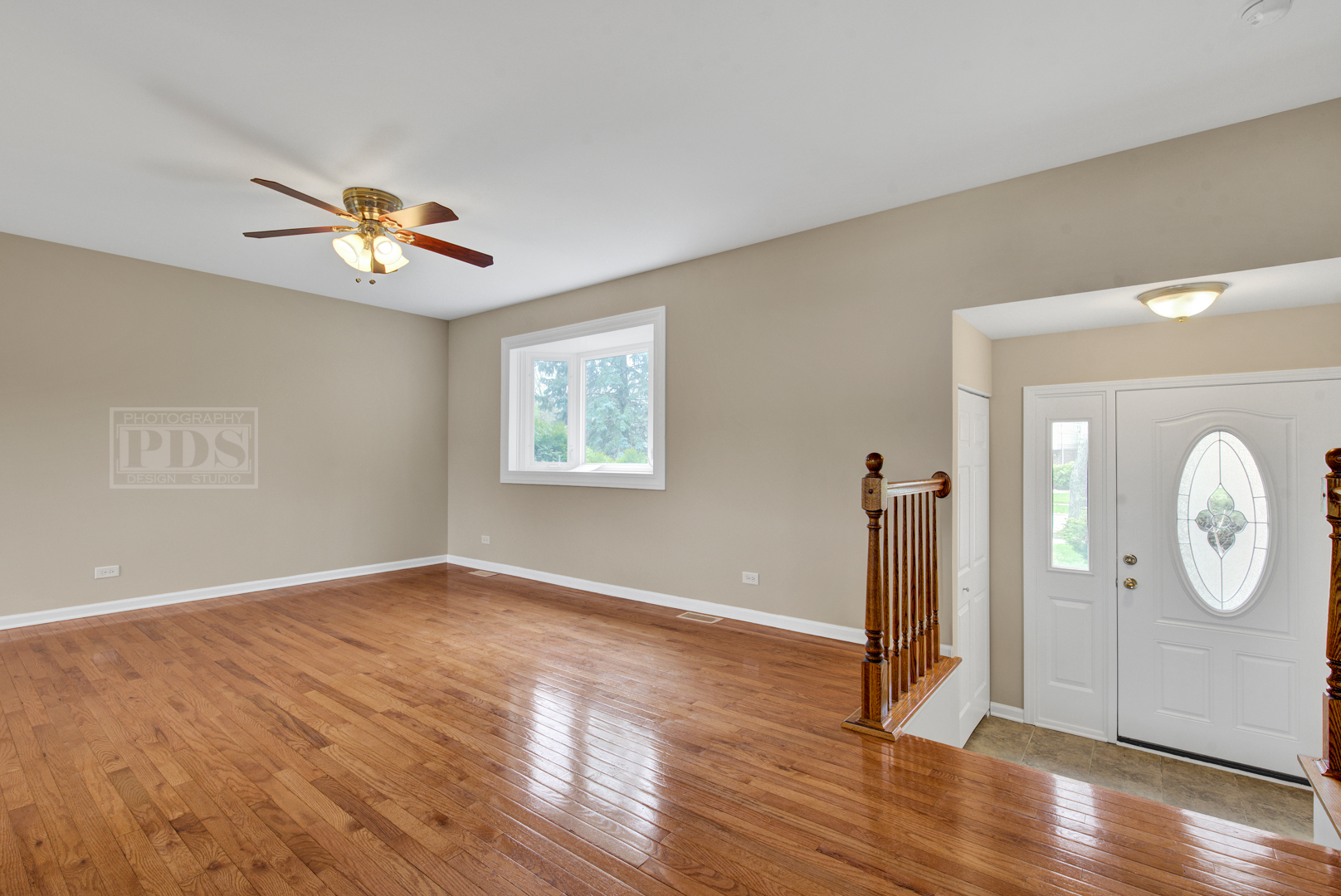 5762 Timberlane Road Matteson, IL 60443 - Photo 2 of 23 a view of a room with wooden floor a ceiling fan and windows