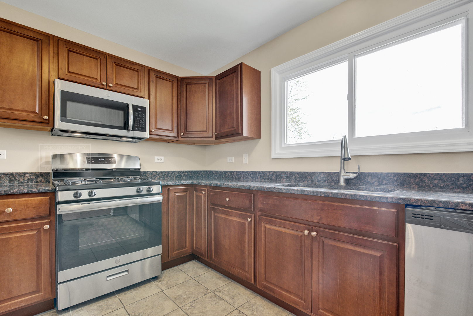 5762 Timberlane Road Matteson, IL 60443 - Photo 8 of 23 a kitchen with granite countertop cabinets stainless steel appliances and a sink